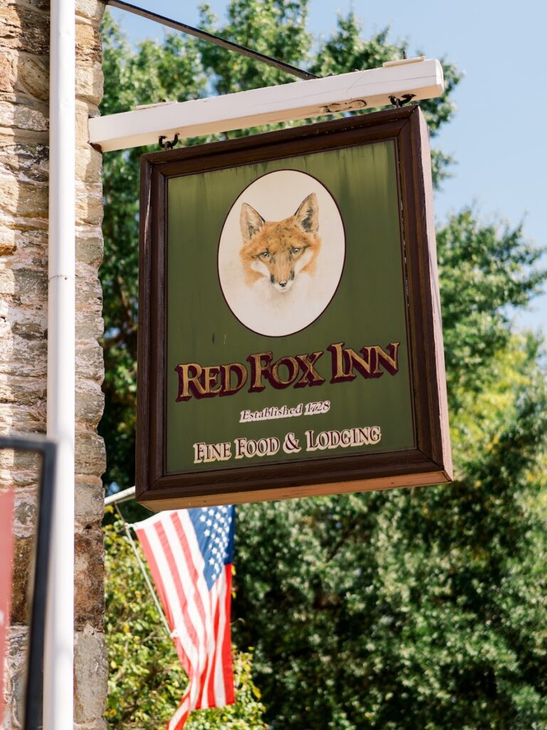 A wooden sign that reads "Red Fox Inn Fine food & lodging" in Middleburg Virginia
