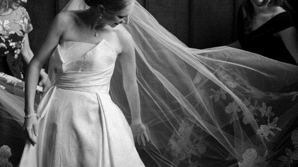 A bride gets dressed in the staircase of District Winery as her veil is fanned out gently behind her 