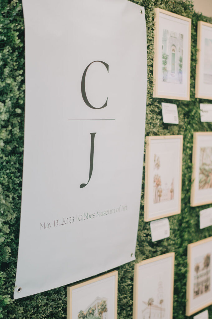 Creative wedding seating chart idea: A gallery of local Charleston art prints with QR codes for an interactive destination wedding guest experience at the Gibbes Museum.