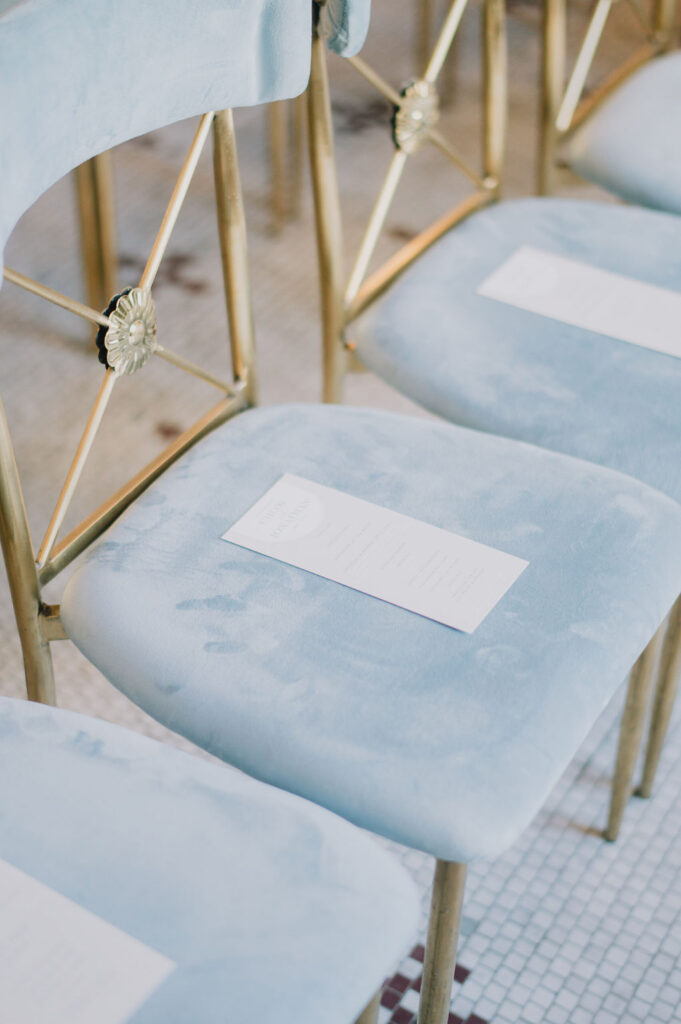 Indoor museum wedding ceremony in the historic Gibbes Rotunda. Elegant Charleston wedding inspiration with sage green velvet chairs and lush white floral arrangements.
