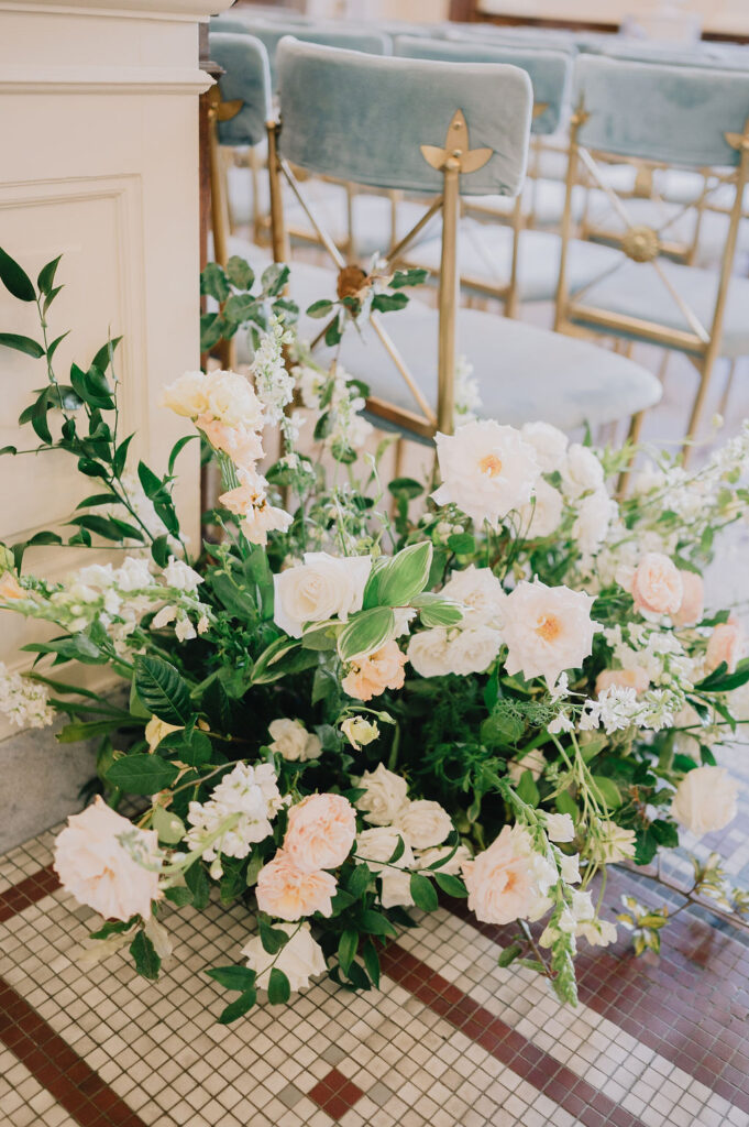 Indoor museum wedding ceremony in the historic Gibbes Rotunda. Elegant Charleston wedding inspiration with sage green velvet chairs and lush white floral arrangements.