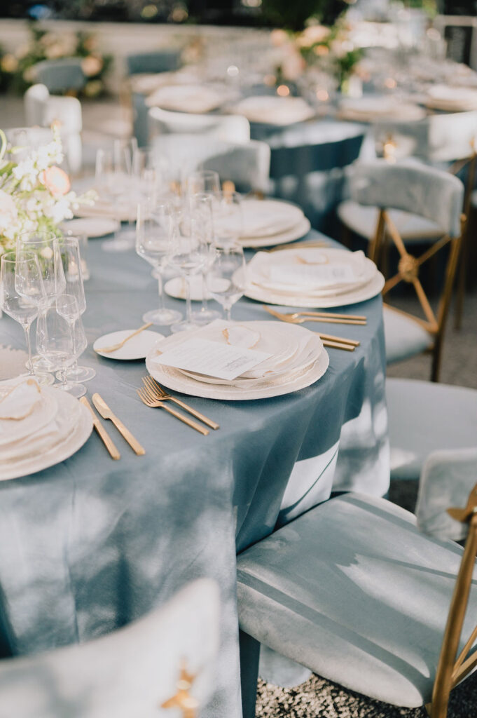 Custom Charleston wedding menu card featuring a Ravenel Bridge sketch, nestled on a stone plate with a rattan charger for a museum wedding reception.